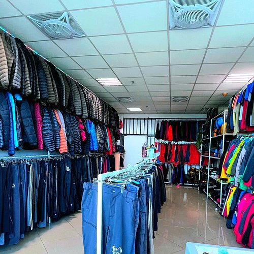 Kilimanjaro trekking gear rental shop with jackets, pants, and hiking clothes neatly displayed on racks