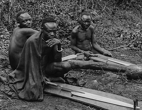 Chagga man forging or shaping a traditional spear by hand in Kilimanjaro region | Kili Quests