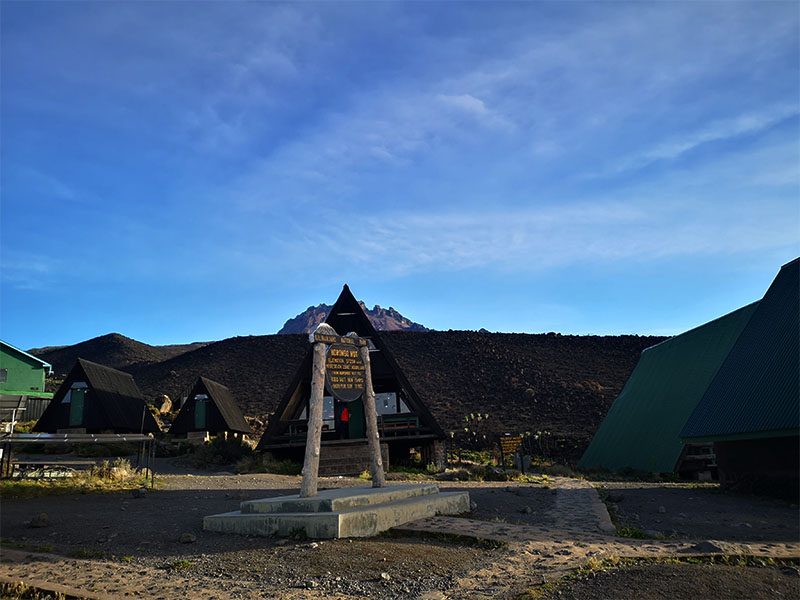 Horombo Huts on Mount Kilimanjaro’s Marangu Route with Mawenzi Peak in the background under a clear blue sky | Kili Quests