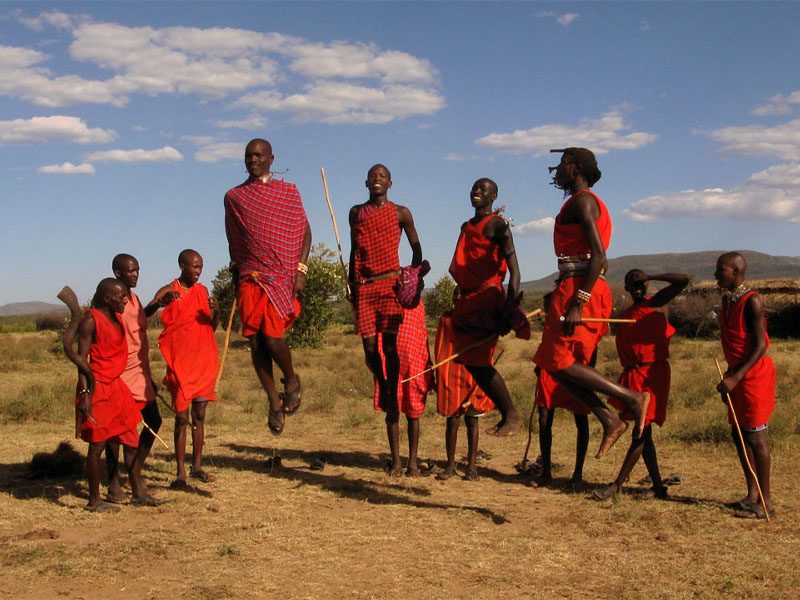 Maasai men performing the traditional Adumu jumping dance in ceremonial attire