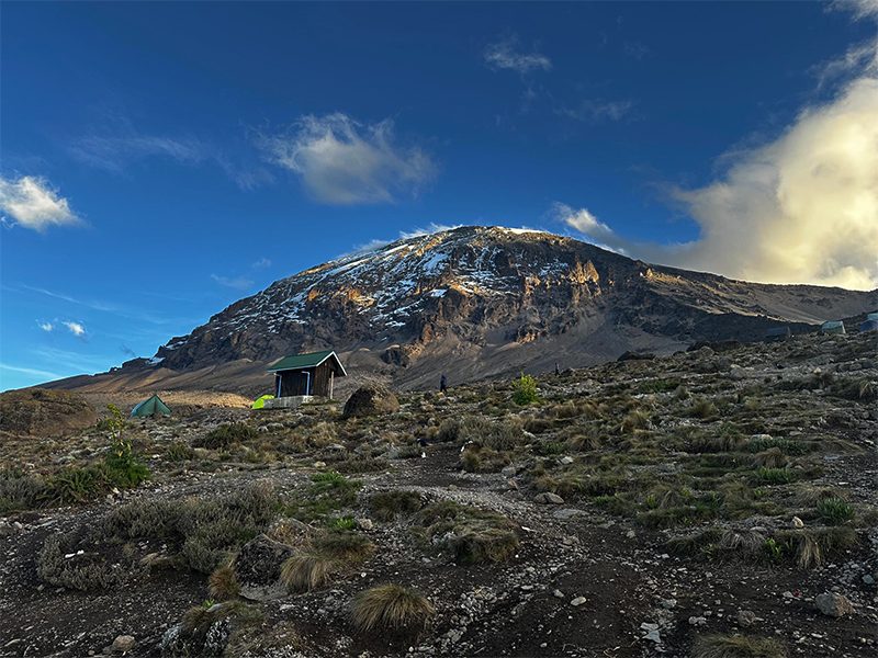 Mount Kilimanjaro rising alone above the African savanna, with snowcapped summit and open sky