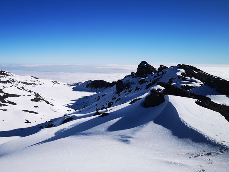 Snow-covered view of Mount Kilimanjaro’s crater rim as seen from Gilman’s Point at sunrise.