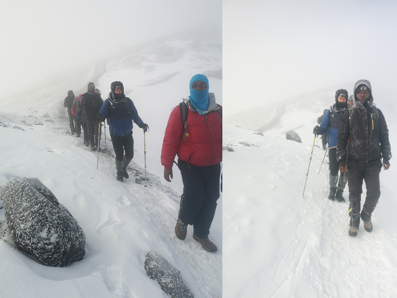 Trekkers and guides hiking through snow near Stella Point on Mount Kilimanjaro during the final summit approach.